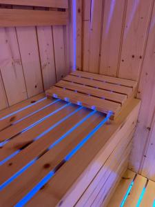 那不勒斯Terrazza Aragon Room and SPA的蓝色灯光桑拿浴室内的木床