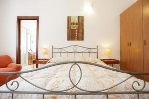 圣塔·马里亚·迪·帕尔玛Bonsai B&B Alghero的一间卧室配有一张床、两张桌子和两盏灯。