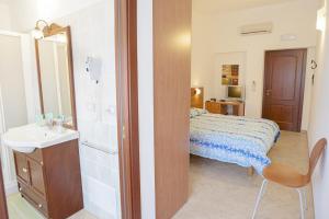 圣塔·马里亚·迪·帕尔玛Bonsai B&B Alghero的一间卧室配有床、水槽和镜子