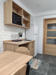 奥波里尼奥Pension Cando的厨房配有桌子和白色冰箱。