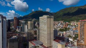 波哥大Tequendama Suites Bogota的享有拥有建筑和山脉的城市美景
