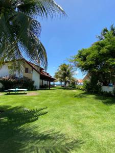嘎林海斯港Paraíso Praia de Maracaípe的一个带野餐桌和树木的绿色庭院