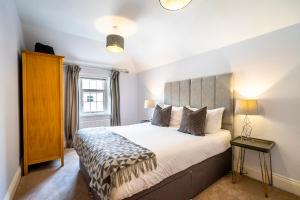 约克Middlethorpe Manor - No 5 Lazy Days and Explore的一间卧室设有一张大床和一个窗户。