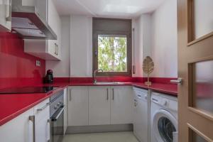 曼雷沙Apartamento ideal en Manresa的红色的厨房设有水槽和洗衣机