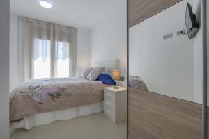 曼雷沙Apartamento ideal en Manresa的一间卧室配有带梳妆台和窗户的床。