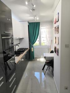 布拉索夫ONYX - Utopia Aparthotel的厨房配有绿帘和桌子