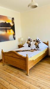 巴特施瓦尔陶gemütliche Wohnung的一间卧室配有一张木床,墙上挂有绘画作品