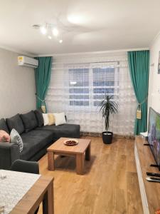 布拉索夫ONYX - Utopia Aparthotel的客厅配有沙发和桌子
