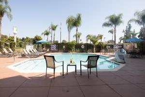 圣安娜圣安娜奥兰治郡机场假日酒店的游泳池前的桌椅