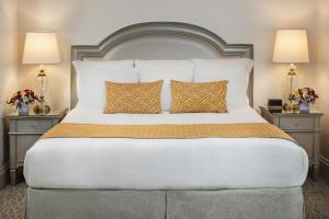 达拉斯华威梅尔罗斯酒店的一间卧室配有一张带2个床头柜的大床