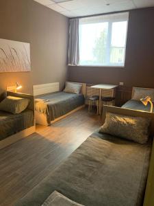 SuoyarviКомфорт центр的客房设有两张床、一张桌子和一扇窗户。