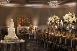 达拉斯华威梅尔罗斯酒店的一间设有桌子的房间,配以婚礼蛋糕和鲜花