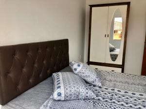 弗洛里亚诺波利斯Apartamento em Floripa -Muito próximo ao Aeroporto的一张带两个枕头的床铺,位于镜子前