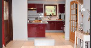 NismesLes Cinq Francais的厨房配有红色橱柜和白色台面