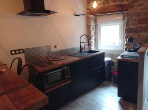 Saint-Jeure-dʼAyL'espaco的厨房配有水槽和炉灶 顶部烤箱