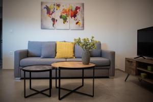 伊古迈尼察LUXURY AUTONOMOUS GROUND FLOOR APARTMENT的客厅配有沙发和带花瓶的桌子