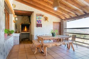 内尔皮奥Casa rural Tio Juan的庭院设有木桌和壁炉。