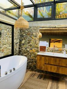 Silvialeremita biohotel的一间带大浴缸和石墙的浴室