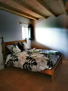 圣若瑟Case Lénaron的一间卧室配有一张带床罩的床和窗户