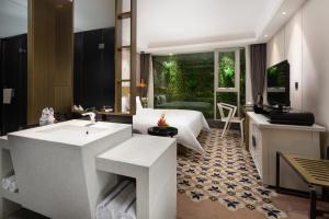 广州Paco Hotel Gangding Metro Guangzhou的浴室配有白色水槽和浴缸。