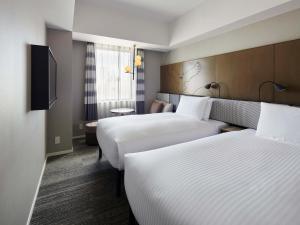 札幌Sapporo Granbell Hotel的酒店客房设有两张床和电视。