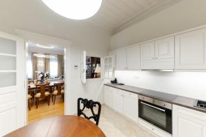 纳夫普利翁Castellano Hotel & Suites的厨房配有白色橱柜、桌子和用餐室。