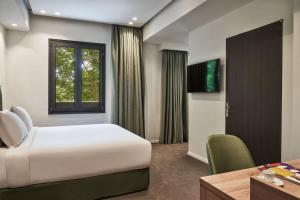 雅典NLH KERAMEIKOS - Neighborhood Lifestyle Hotels的一间卧室配有一张床、一张书桌和一个窗户。