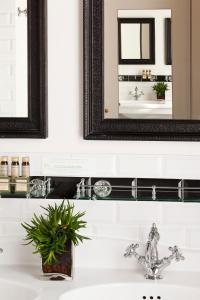巴黎Hôtel Sainte-Beuve的浴室水槽设有黑色框架镜和镜子