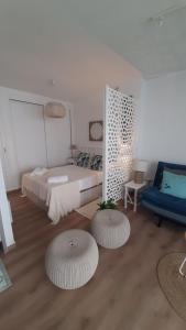 福恩吉罗拉Apartment Fuengirola Carvajal beach front Málaga Spain的一间卧室配有一张床和两张搁脚凳