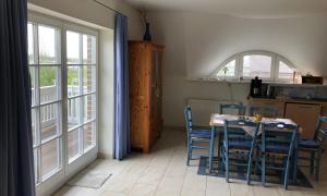 奥茨塞巴德·迪尔哈根"Koppeldeich"的一间带桌椅和窗户的用餐室
