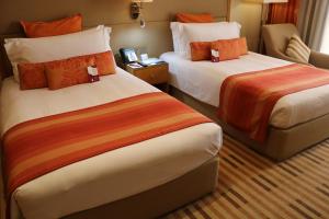 索哈尔索哈尔皇冠假日酒店的酒店客房 - 带两张带橙色枕头的床
