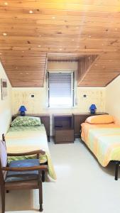 贾迪尼-纳克索斯Tiziana的一间卧室设有两张床和木制天花板