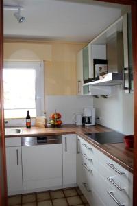 埃肯弗德Borgers的厨房配有白色橱柜、水槽和窗户。