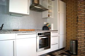 斯塔贝多福Inselhaus OG的一间厨房,配有白色家电和砖墙
