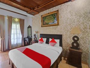BangkoOYO Life 11350O Hotel R Cantika Syariah的一间卧室配有一张带红白毯子的床