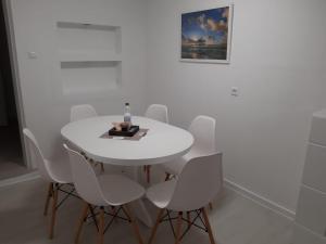 海德Ferienhaus Heide Zentrum的白色的用餐室配有白色的桌椅