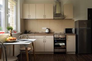 维尔纽斯4 Apartment Between Two Lakes的厨房配有桌子和不锈钢冰箱。