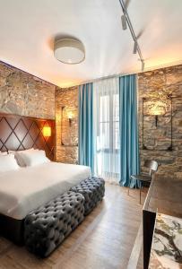的里雅斯特Hotel Solun的一间卧室配有一张带蓝色窗帘的大床