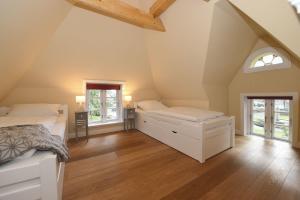 奥埃费努姆Uns witte Kaat的阁楼卧室设有两张床和两个窗户。