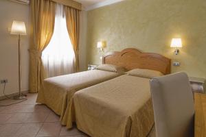 阿尔巴塔克斯Hotel La Perla的酒店客房设有两张床和窗户。
