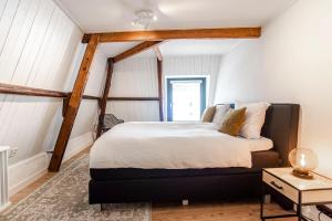 赞德沃特Casa by Sellas的一间设有一张大床的卧室,位于白色墙壁的房间