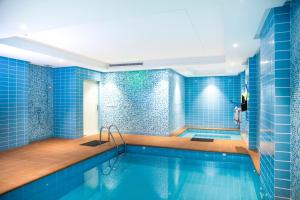 吉达Swiss Blue Hotel Hera的浴室设有蓝色瓷砖的游泳池