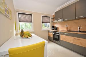 不莱梅Business Apartments Bremen Typ 4的厨房配有白色的柜台和黄色的椅子