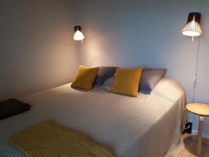 汉科Graniitti的一间卧室配有一张带黄色枕头和两个灯的床。