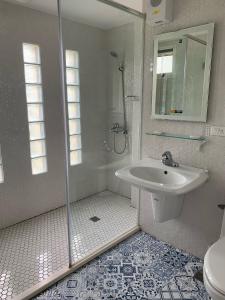 Yung-an-ts'un贝尔庄园民宿的带淋浴和盥洗盆的白色浴室