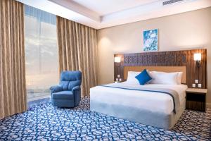 吉达Swiss Blue Hotel Hera的配有一张床和一把椅子的酒店客房