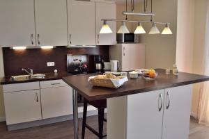 斯塔贝多福Fehmarnstrand 78 App 14的厨房配有白色橱柜和木制台面