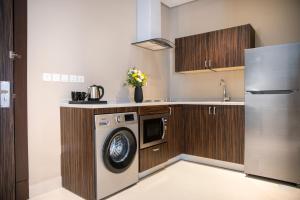 吉达Swiss Blue Hotel Hera的厨房配有洗衣机和冰箱。