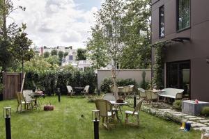 巴黎Hôtel Botaniste的草地上带桌椅的庭院