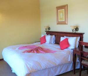 伯格维尔桑福德公园乡村酒店 的一间卧室配有一张带红色枕头的大床